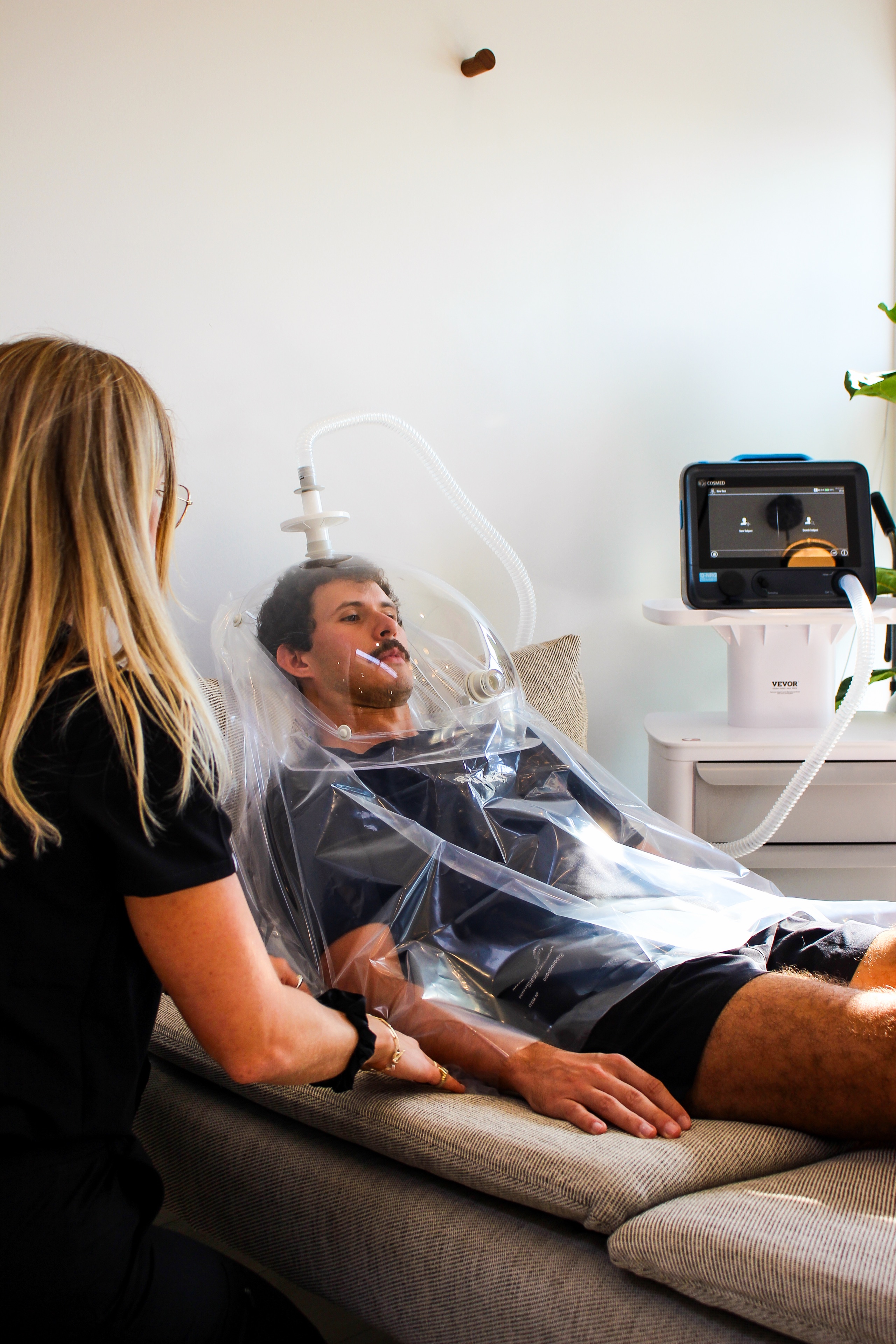 Patient resting under a metabolic hood during a resting metabolic rate test
